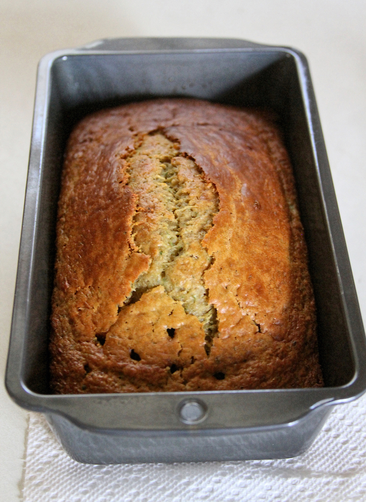 Close-up of a loaf and slice of moist, sweet and mouth watering zucchini bread, a holiday dessert treat still warm from the oven
