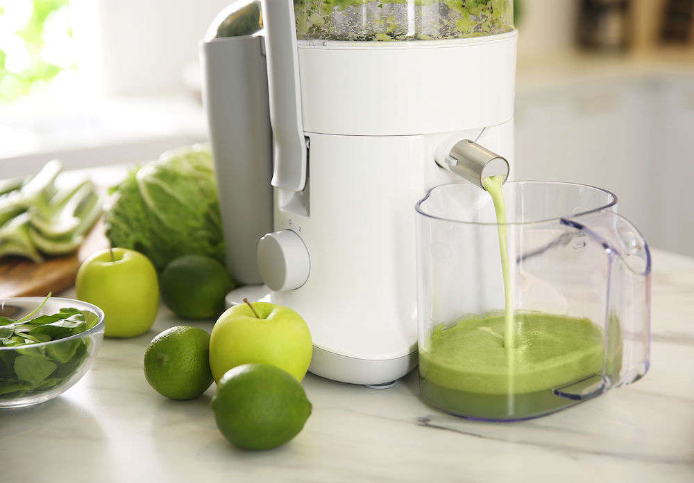 Modern juicer and fresh fruits on table in kitchen
