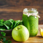Fresh healthy green spinach and apple smoothie served in jar with lemon for diet and detox.Smoothie fruit detox breakfast. Green smoothie detox diet. Diet fruit and vegetable smoothie. Green Smoothie. Green detox diet smoothie. Green veggie smoothie detox.