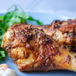 close up of Spiced Chicken Drumsticks and salad on a blue plate