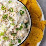 Corn Dip in a white bowl served with tortilla chips