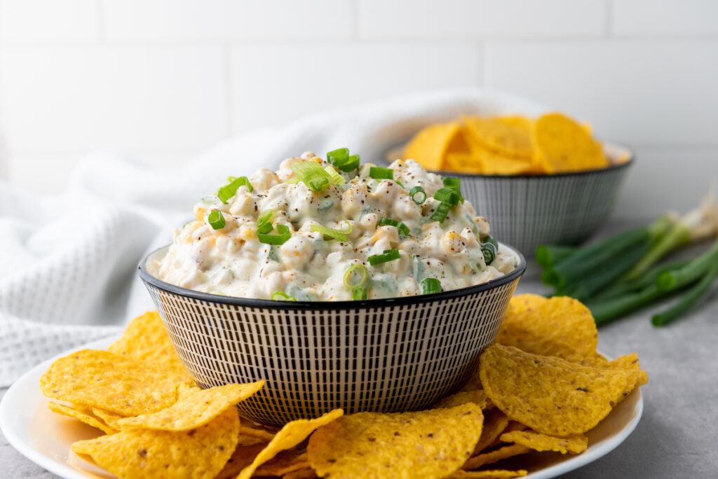 Corn Dip in a textured bowl served with tortilla chips