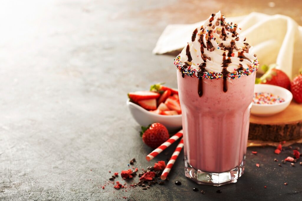 Strawberry milkshake with whipped cream and chocolate syrup with copyspace