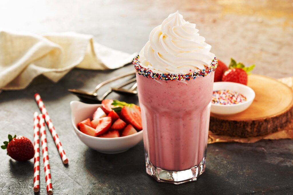 Strawberry milkshake with whipped cream and chocolate syrup